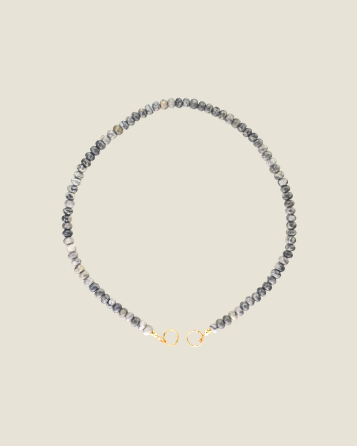 Ordoñez Le Theia Strand necklace with gray map jasper beads and gold-colored end rings, from the official brand website
