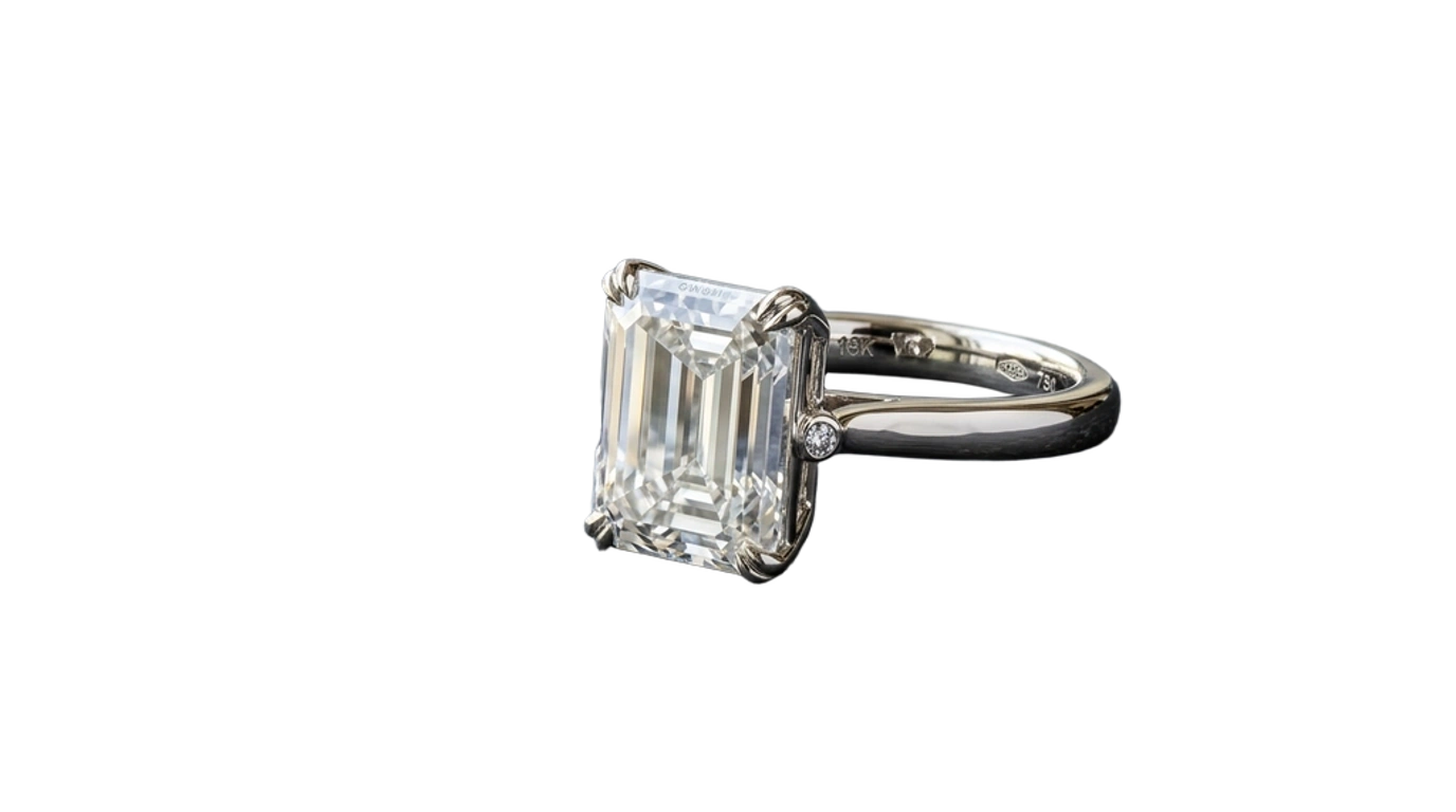 Isolated emerald-cut diamond ring cutout with preserved step-cut facets and 18k white gold luster